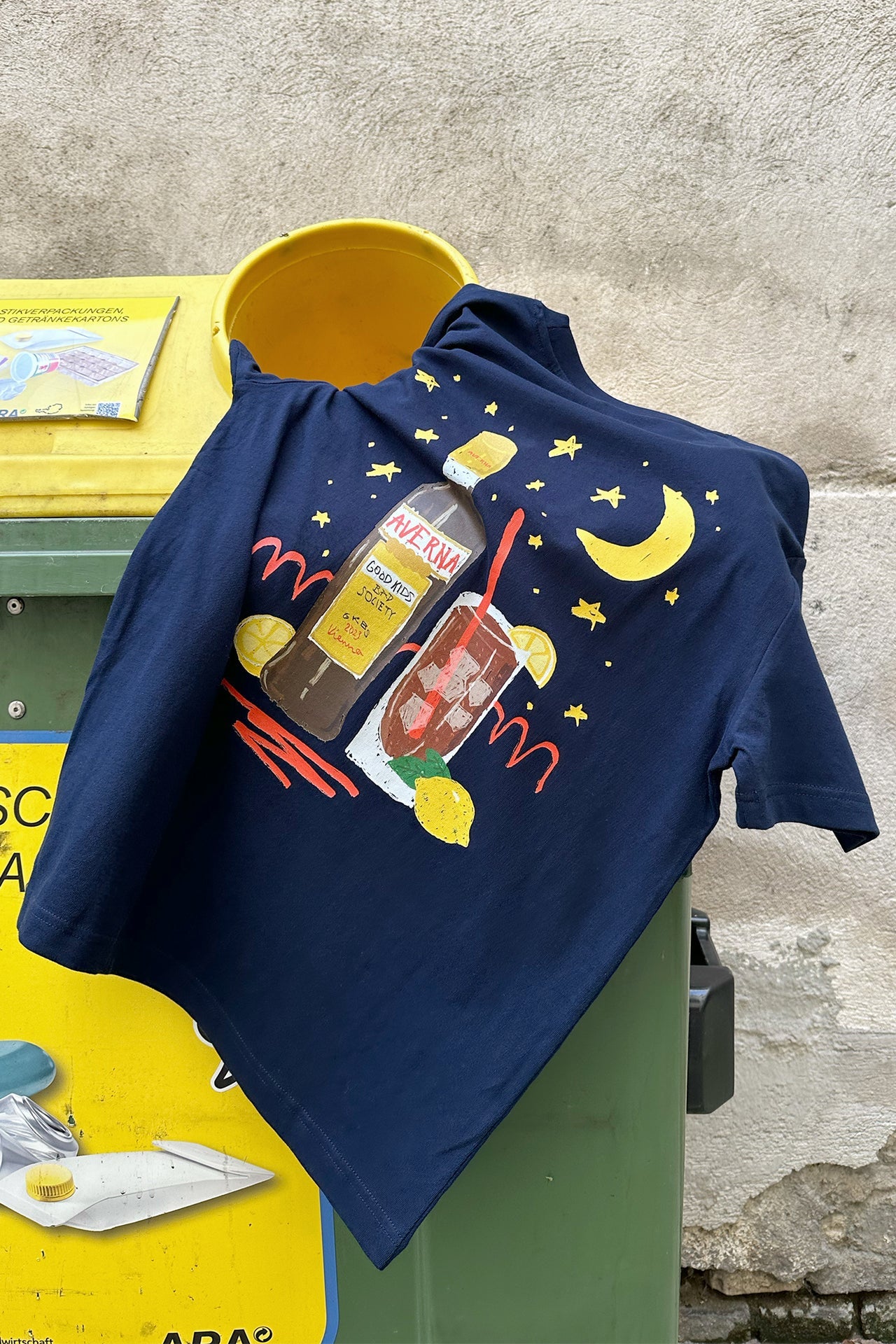 Navy Wien Streetwear T-Shirt auf Altpapiercontainer, Rückenprint Averna-Illustration mit Mond, Sternen und Zitrone