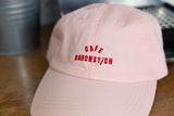 Nahaufnahme roter Cafe Bauchstich Stickerei auf rosa Wien Dad Cap, zweiteilige Schrift auf Baumwollstoff