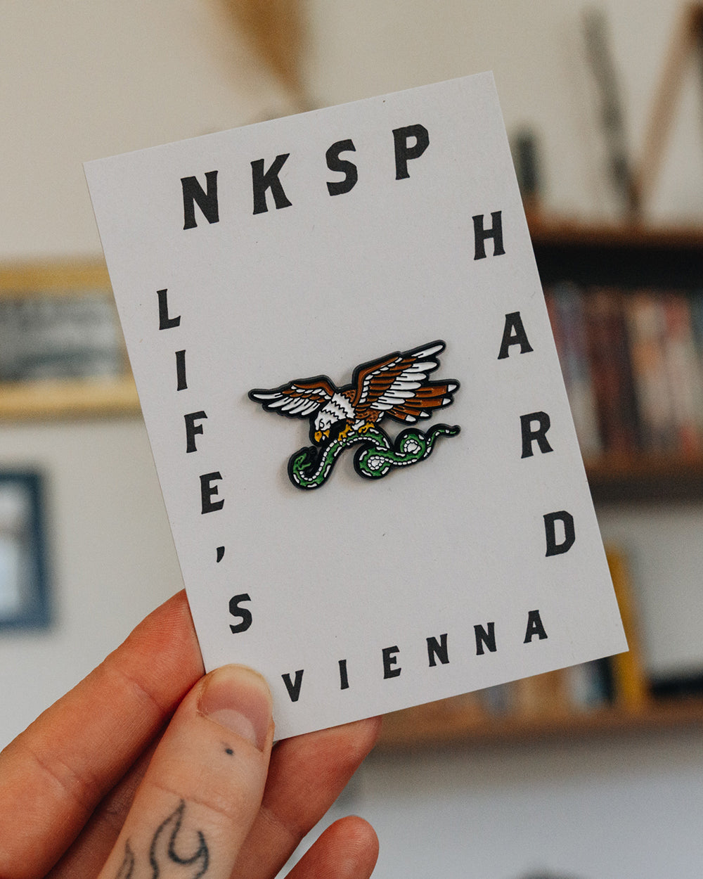 Life's Hard Pin von NKSP – Adler-Pin auf Karte mit Aufschrift Life's Hard Vienna