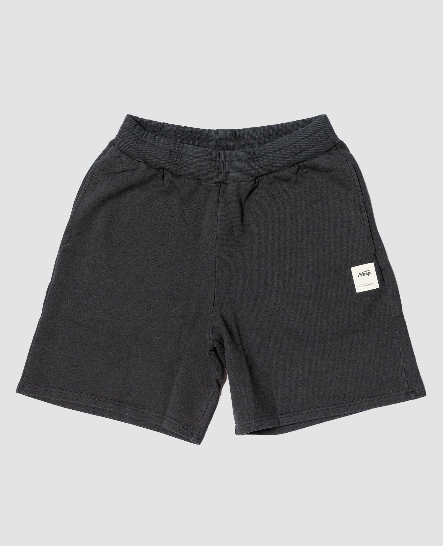 SFW Shorts Schwarz von NKSP – Sweatshorts flach gelegt mit gewebtem Label am Bein