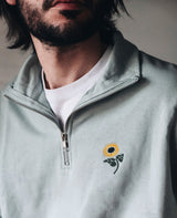 Half-Zip Sweatshirt Salbeigrün von NKSP – Stehkragen, Reißverschluss und Sonnenblumenstickerei am Model