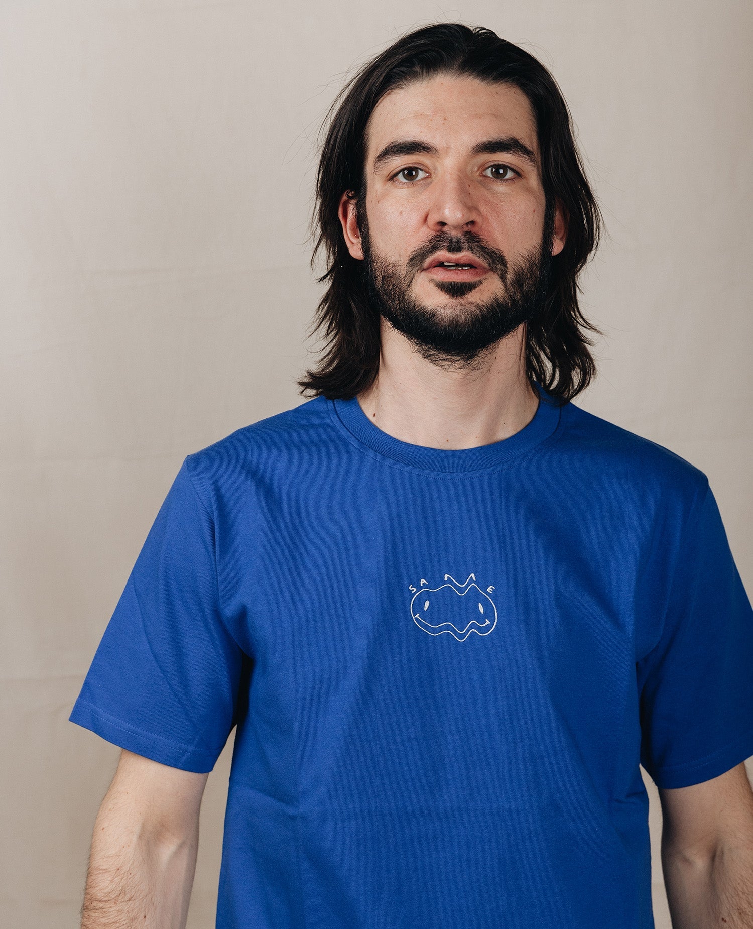 Same Tee Blau von NKSP – Vorderansicht am Model mit Smiley-Stickerei