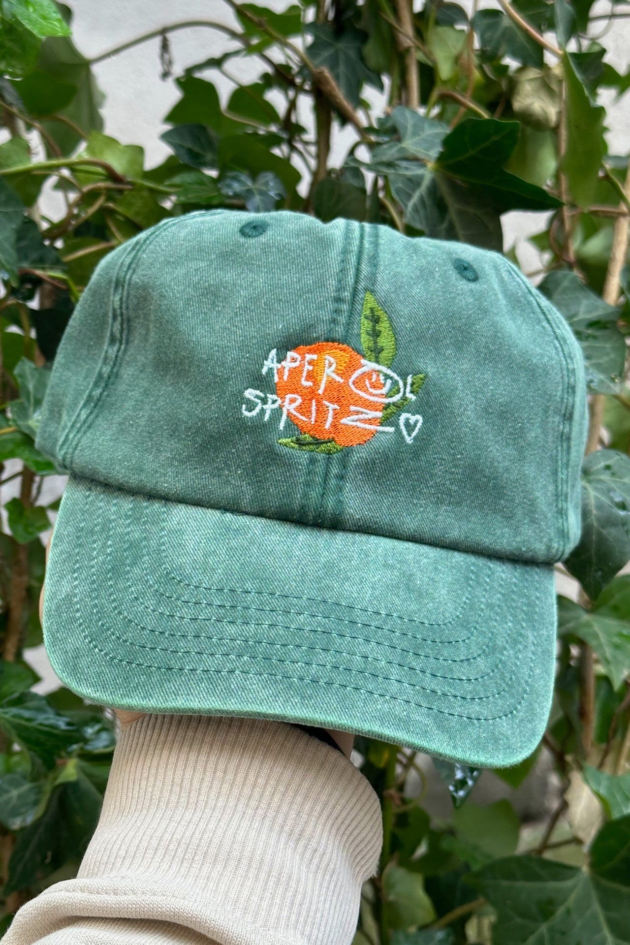Wien Streetwear Dad Cap in Vintage Green, bestickt mit Aperol Spritz Schriftzug und Orange-Motiv, Bio Baumwolle
